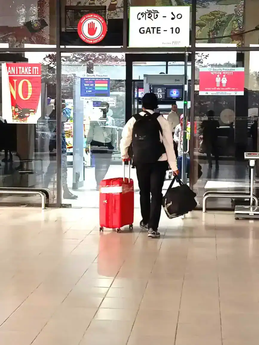 Crew member with luggage moving through airport immigration control